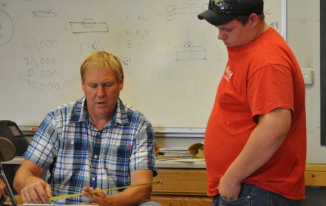 Shop teacher Tom Harman, left, works with senior Dalton Swafford in Drafting class. 