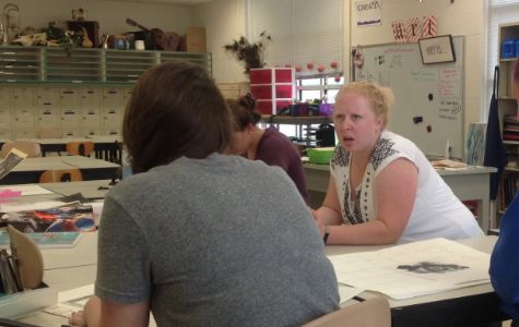 Becky Weaver, the new art teacher, helps students in her AP Art class.