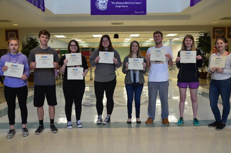 Journalism students received award certificates for their work at KSPA Regionals. From left to right: Rachael Fritzsche, Garrett Owings, Grace Cooper, Emily Bennett, Quinna Lund, Hayden Burkhart, Jessi Dowell, Ellie Thurlow.