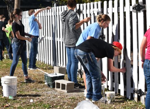 BHS freshman helping the community on Community Service Day by repainting a fence down town. 