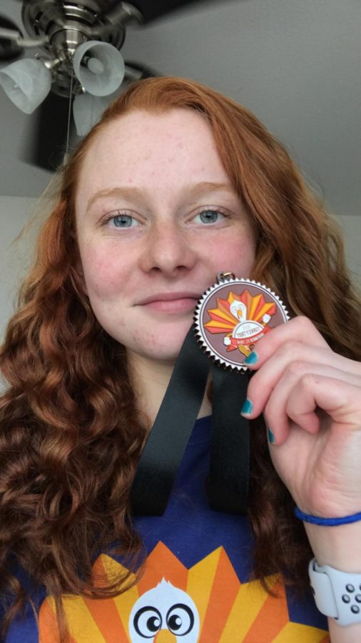 Olivia Miller holding a medal from one of her races.