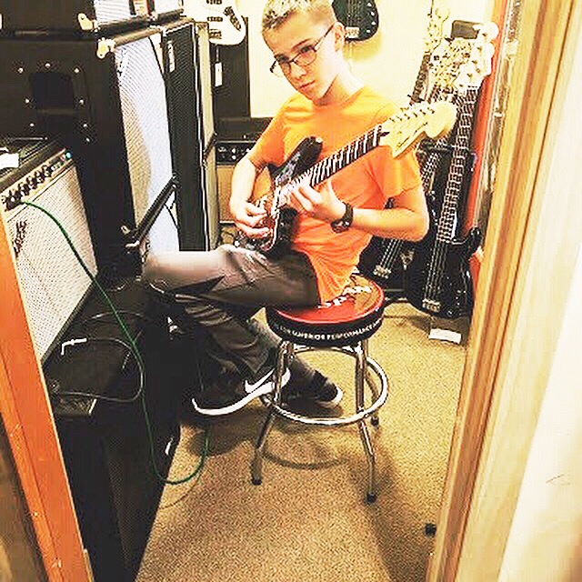 Lucas tests out a guitar before he decides to buy it.