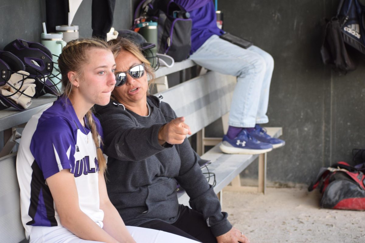 Coach Melissa Alford telling Emme Nigh  what to do on a certain play.